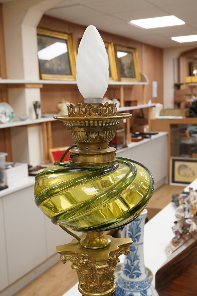 A 19th century gilt and brass green glass corinthian columned oil lamp by Messenger, 68cm high
